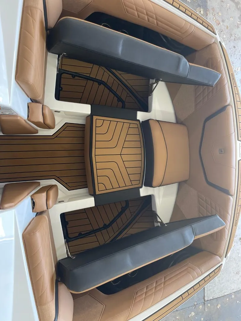 Slide: The Image of 2024 Nautique Super Air Nautique G23 interior with tan and black seating. - 24