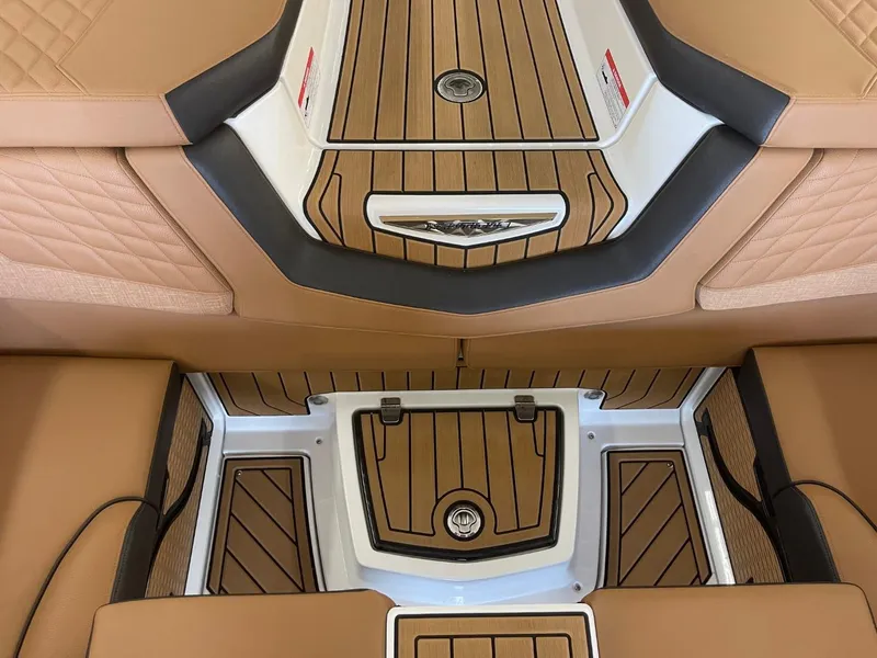 Slide: The Image of 2024 Nautique Super Air Nautique G23 interior with tan upholstery and teak flooring. - 25