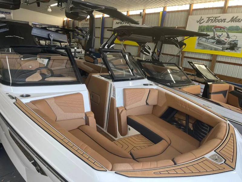 Slide: The Image of 2024 Nautique Super Air Nautique G23 boat with luxurious tan interior in showroom. - 37