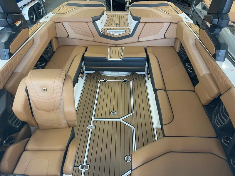 Slide: The Image of 2024 Nautique Super Air Nautique G23 interior with luxurious tan seating and wood flooring. - 4