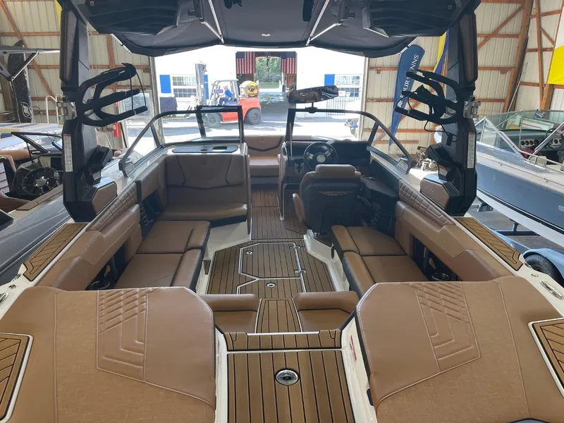 Slide: The Image of 2024 Nautique Super Air Nautique G23 interior with tan seating and wood accents. - 5