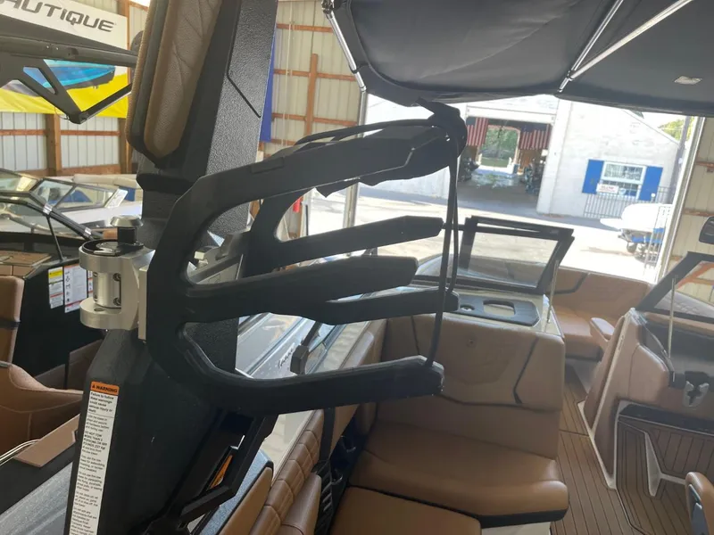 Slide: The Image of 2024 Nautique Super Air Nautique G23 interior with wakeboard rack in a boat garage. - 8