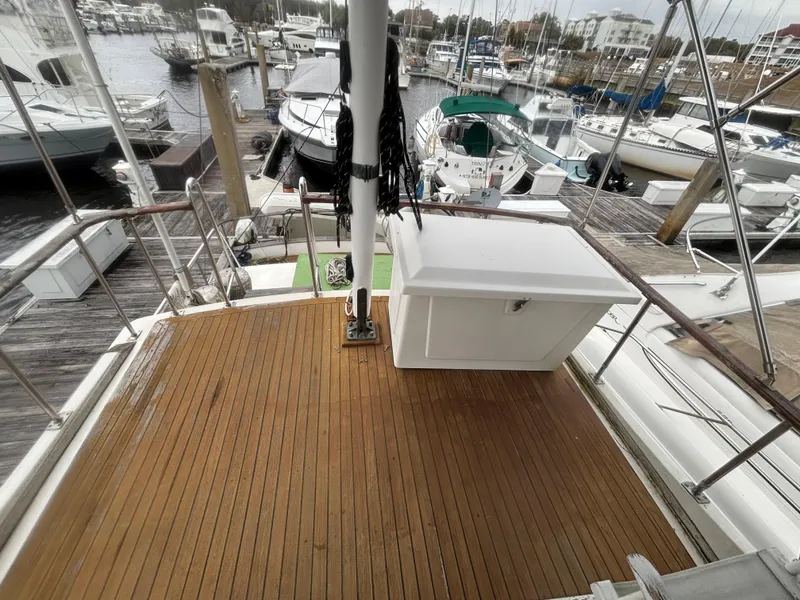 Slide: The Image of 1983 Albin Double Cabin boat deck with wooden flooring, docked at a marina. - 17