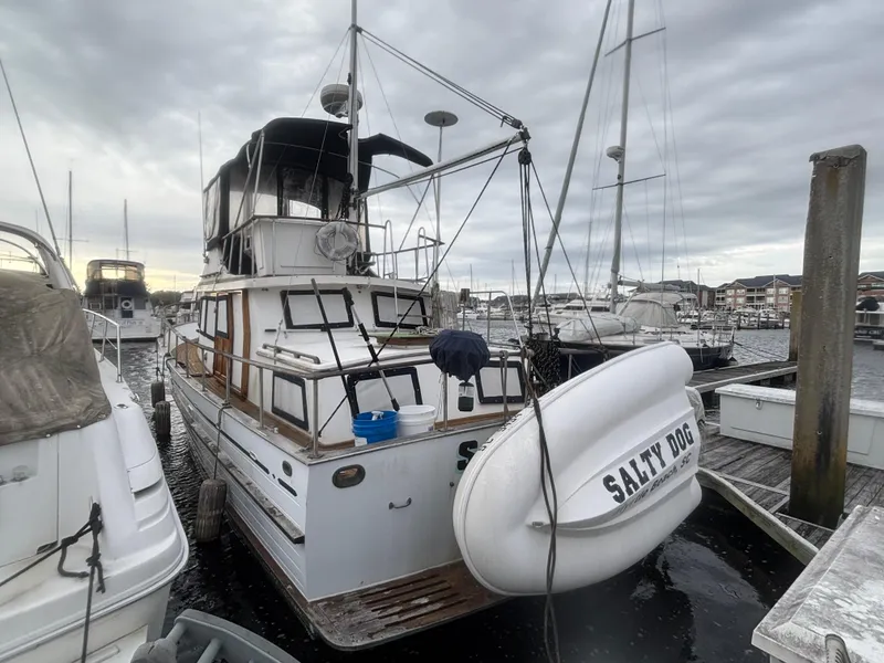 Slide: The Image of 1983 Albin Double Cabin boat docked with "Salty Dog" dinghy attached. - 2