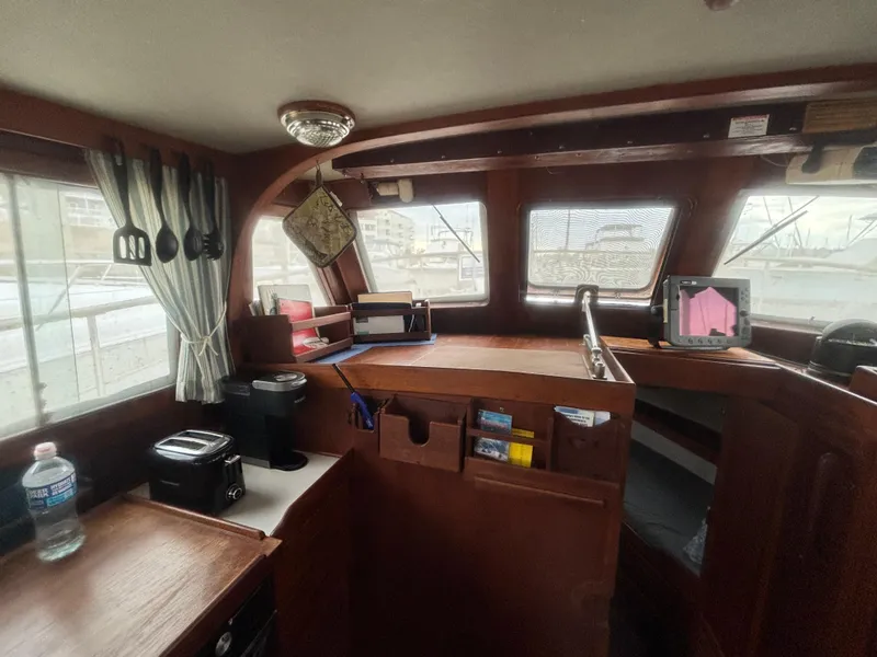 Slide: The Image of Interior of a 1983 Albin Double Cabin boat with wooden furnishings and nautical equipment. - 23