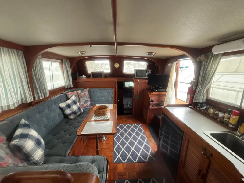Slide: The Image of 1983 Albin Double Cabin interior with cozy seating, wooden accents, and nautical decor. - 25