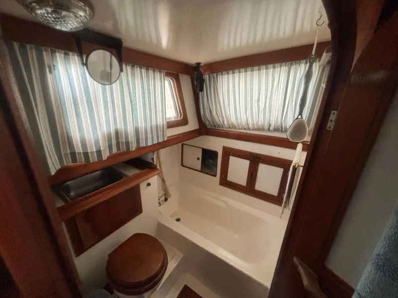 Slide: The Image of 1983 Albin Double Cabin bathroom with wood accents and striped curtains. - 36