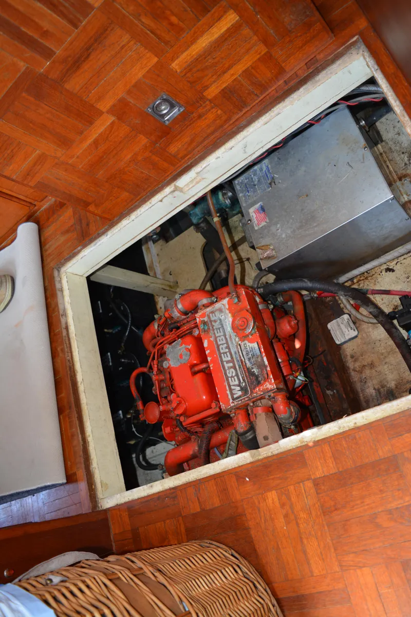 Slide: The Image of 1983 Albin Double Cabin engine compartment with visible red engine and wooden flooring. - 46