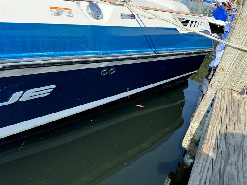 Slide: The Image of 2018 Nautique Super Air Nautique GS24 docked, blue and white hull visible. - 16