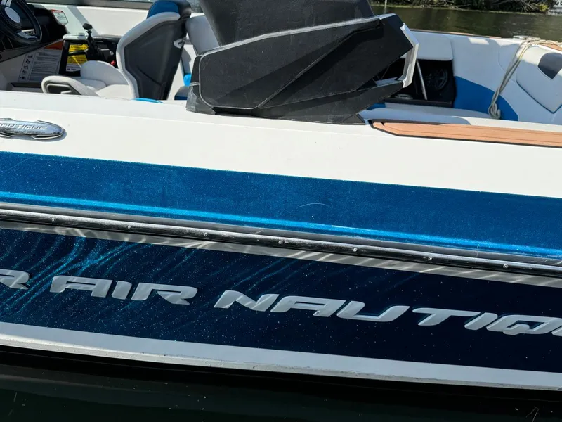 Slide: The Image of 2018 Nautique Super Air Nautique GS24 boat, blue and white exterior, close-up view. - 17