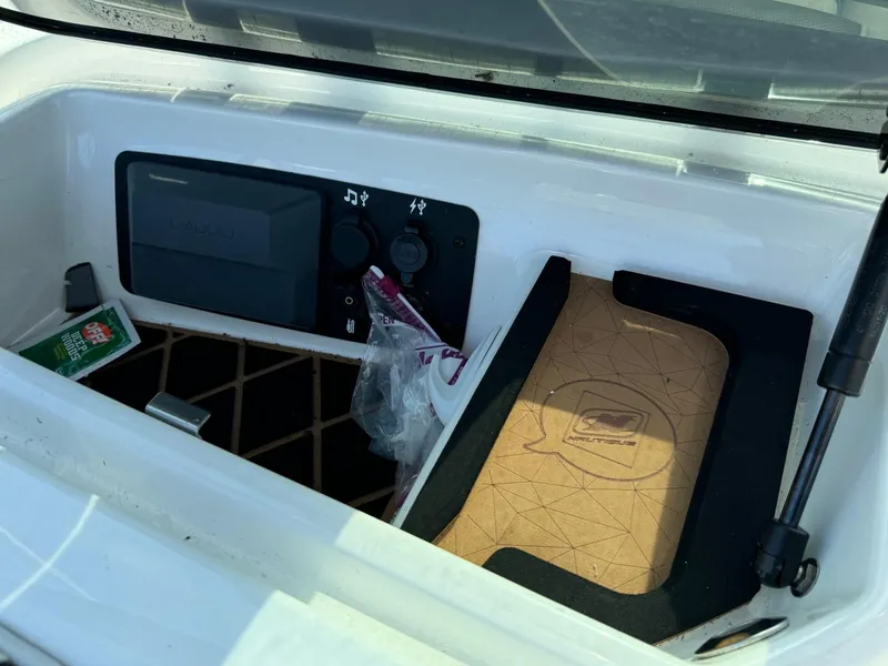 Slide: The Image of Storage compartment of 2018 Nautique Super Air Nautique GS24 boat with controls and accessories. - 25