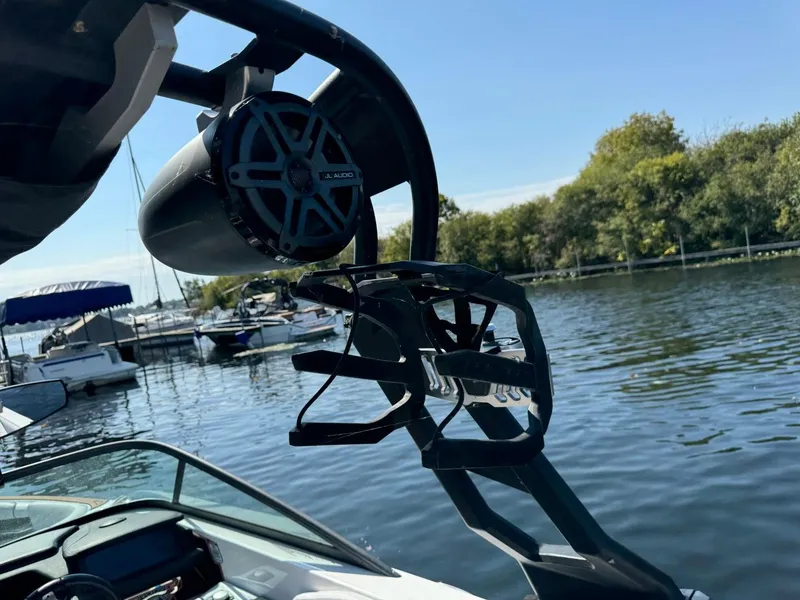 Slide: The Image of 2018 Nautique Super Air Nautique GS24 boat with speaker and wakeboard rack on a sunny day. - 45