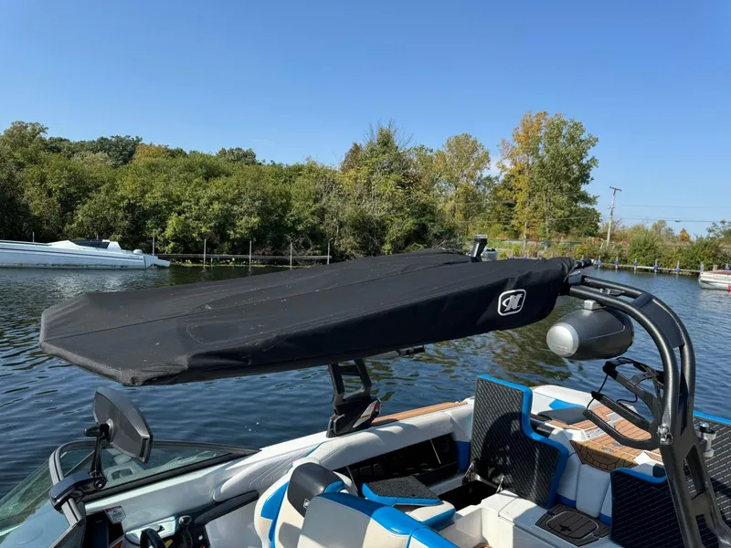 Slide: The Image of 2018 Nautique Super Air Nautique GS24 boat on a calm lake with trees in background. - 47