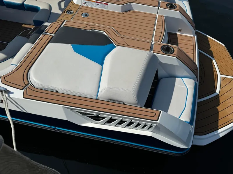 Slide: The Image of 2018 Nautique Super Air Nautique GS24 boat with cushioned seating and sleek design. - 7