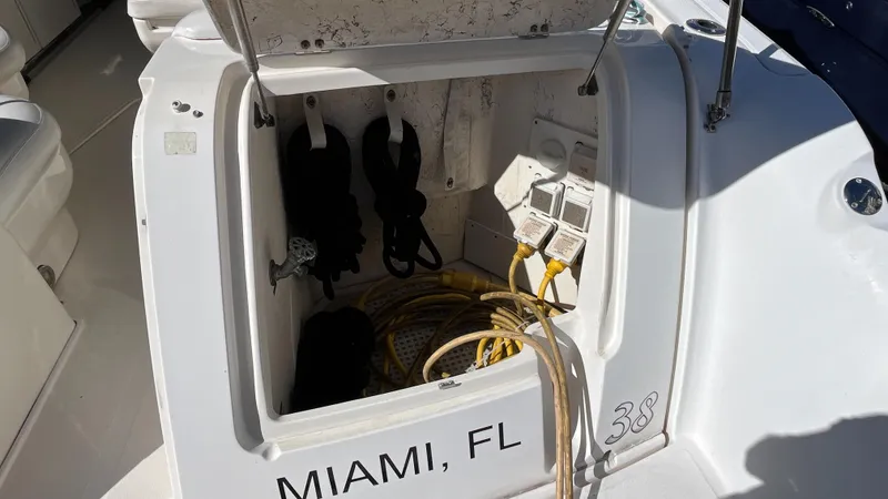 Slide: The Image of Open storage compartment on 2008 Sea Ray 380 Sundancer, Miami, FL, with cables and equipment. - 13