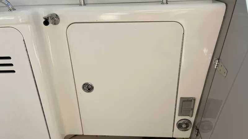 Slide: The Image of 2008 Sea Ray 380 Sundancer boat compartment with latch and control panel. - 17