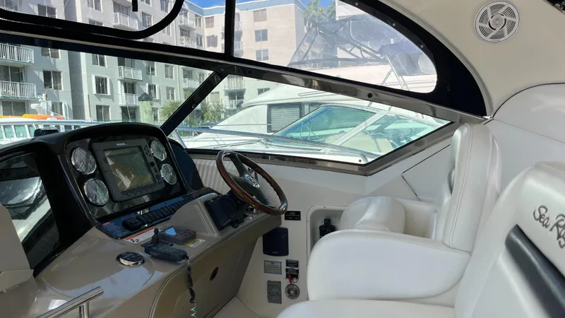 Slide: The Image of 2008 Sea Ray 380 Sundancer cockpit with modern controls and white seating. - 23