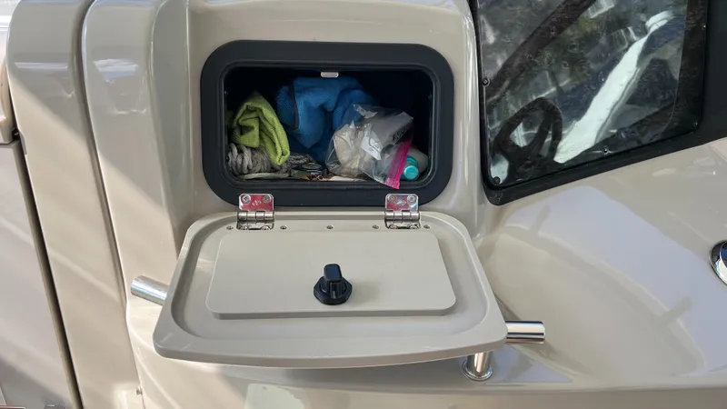 Slide: The Image of Storage compartment on a 2008 Sea Ray 380 Sundancer boat, containing various items. - 30
