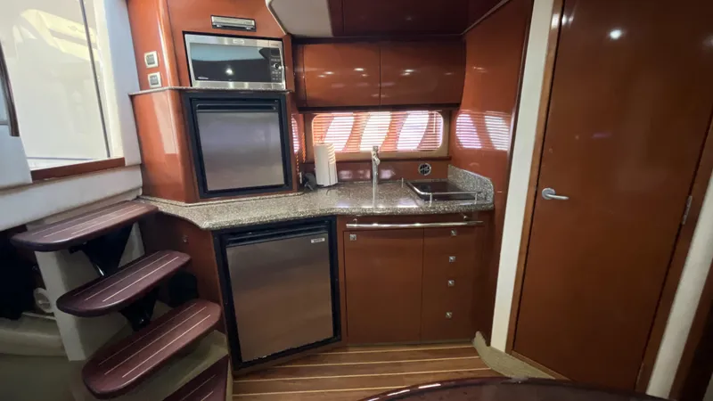 Slide: The Image of 2008 Sea Ray 380 Sundancer yacht kitchen with modern appliances and wood finish. - 35