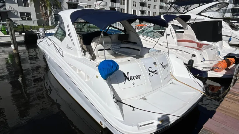 Slide: The Image of 2008 Sea Ray 380 Sundancer yacht docked at marina, featuring blue canopy and sleek design. - 4