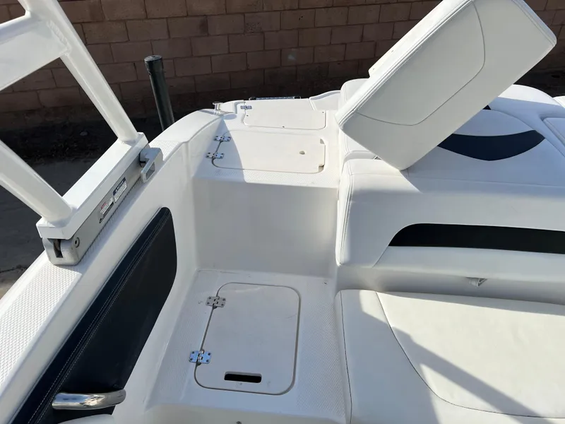 Slide: The Image of 2017 Chaparral 19 H2O Sport boat interior with white seating and storage compartments. - 21