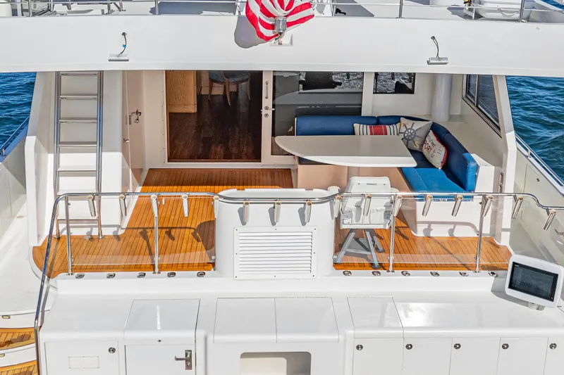 Slide: The Image of Nordlund 1995 Cockpit Motor Yacht with outdoor seating, table, and American flag. - 25