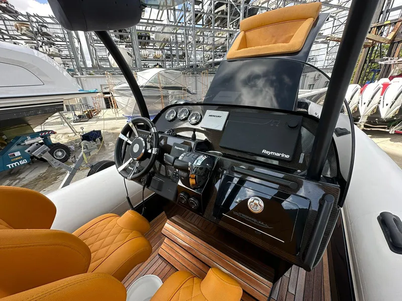 Slide: The Image of 2019 Technohull SeaDNA 999 G5 cockpit with orange seats and modern navigation equipment. - 1