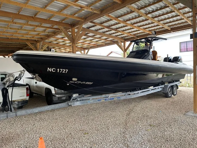 Slide: The Image of 2019 Technohull SeaDNA 999 G5 boat on trailer under a metal roof. - 15