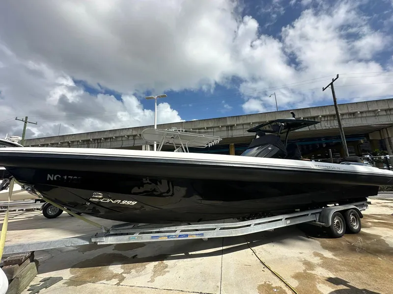 Slide: The Image of 2019 Technohull SeaDNA 999 G5 boat on trailer under cloudy sky. - 2