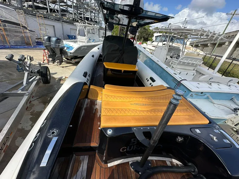 Slide: The Image of 2019 Technohull SeaDNA 999 G5 boat with orange seating, docked at a marina. - 9
