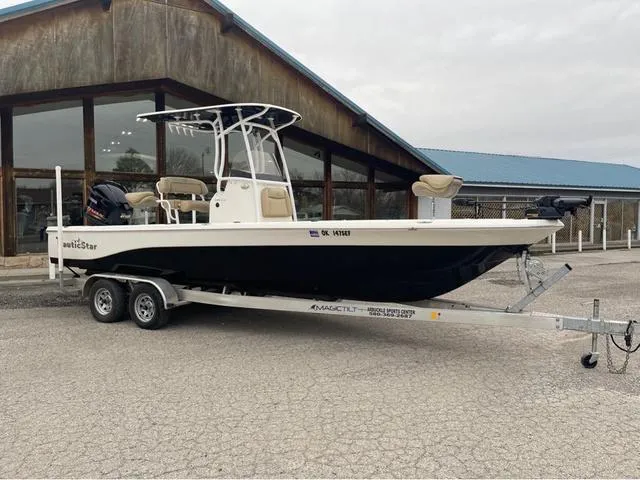 Slide: The Image of 2019 NauticStar 244XTS boat on trailer under clear blue sky. - 1