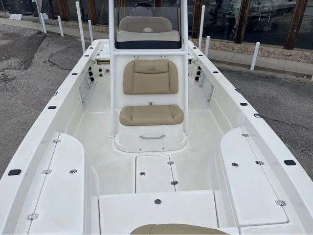 Slide: The Image of 2019 NauticStar 244XTS boat interior with beige seating and white deck. - 17