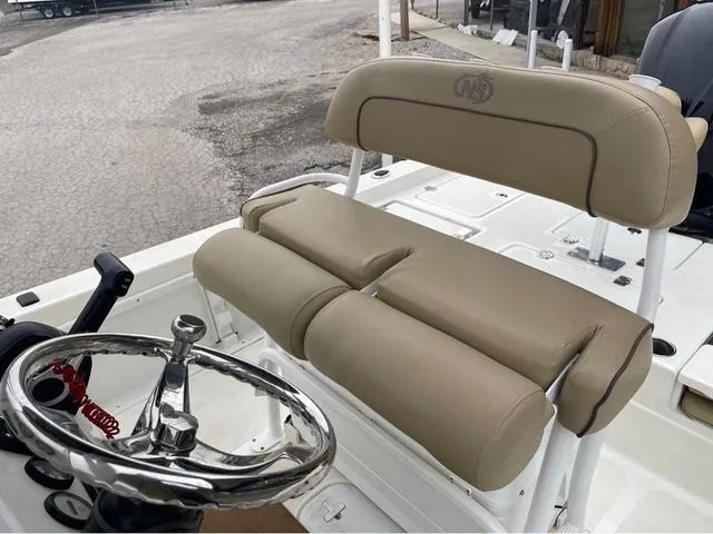 Slide: The Image of 2019 NauticStar 244XTS boat interior with beige seating and chrome steering wheel. - 20