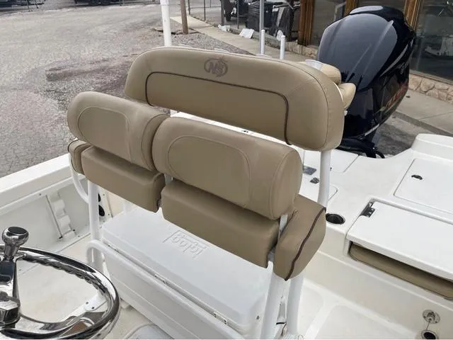 Slide: The Image of 2019 NauticStar 244XTS boat with beige cushioned seating and steering wheel. - 21