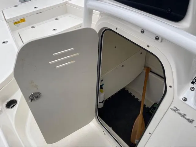 Slide: The Image of 2019 NauticStar 244XTS boat storage compartment with open door and paddle inside. - 31