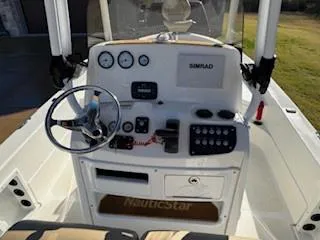 Slide: The Image of 2019 NauticStar 244XTS boat interior with tan seating and motor. - 4