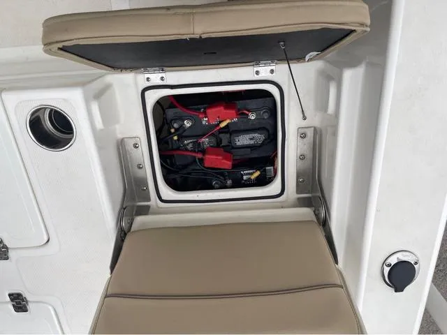 Slide: The Image of Open battery compartment on 2019 NauticStar 244XTS boat with beige seating. - 40