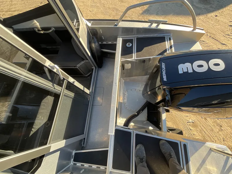 Slide: The Image of 2023 Viggo C8 boat with Mercury engine, viewed from above on sandy ground. - 12