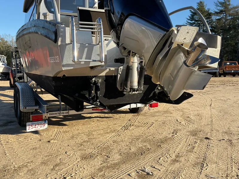 Slide: The Image of 2023 Viggo C8 boat on trailer, rear view with outboard motor, parked on sandy ground. - 7