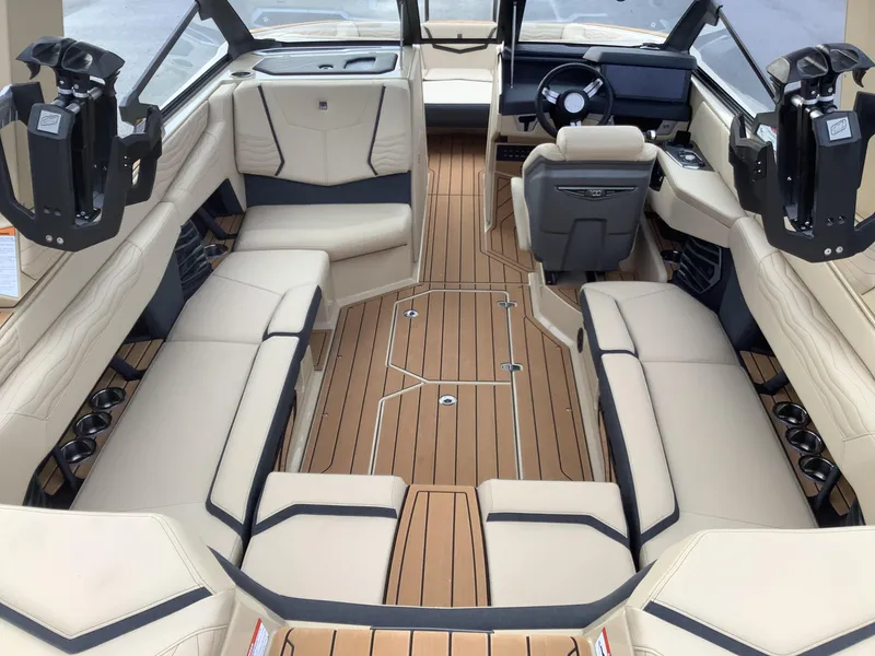Slide: The Image of Luxurious interior of 2025 Nautique G23 boat with beige seating and wood flooring. - 10