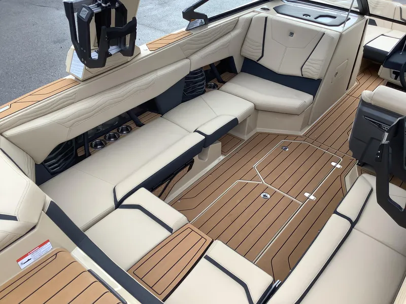 Slide: The Image of 2025 Nautique G23 boat interior with beige seating and teak flooring. - 12