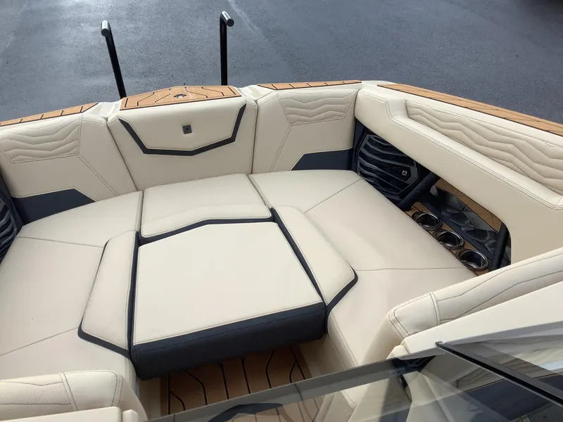Slide: The Image of 2025 Nautique G23 boat interior with luxurious beige seating and cup holders. - 17