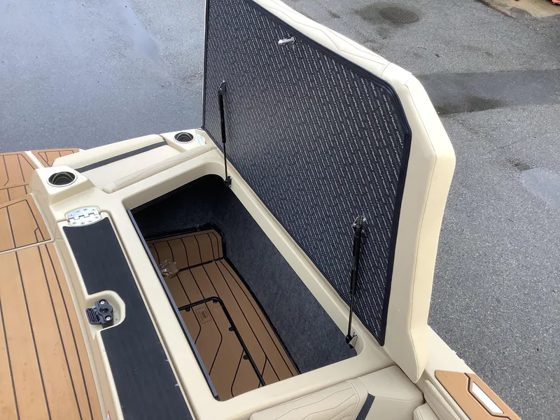 Slide: The Image of 2025 Nautique G23 boat storage compartment with open lid, showcasing interior space. - 18