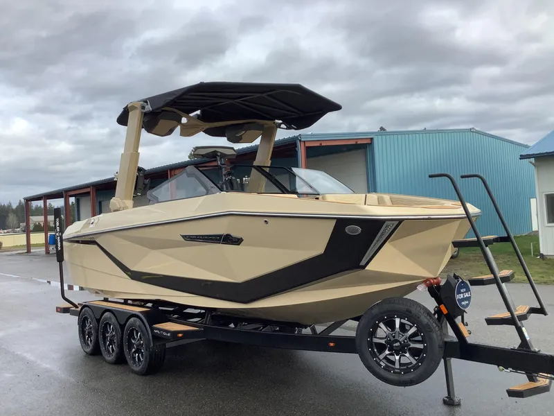 Slide: The Image of 2025 Nautique G23 boat on trailer, parked outdoors under cloudy sky. - 4