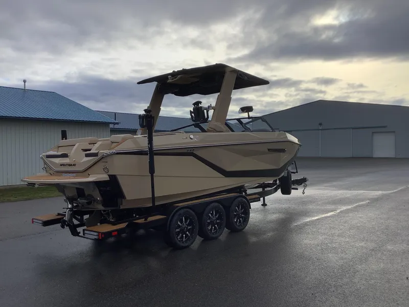 Slide: The Image of 2025 Nautique G23 boat on trailer, parked outdoors under cloudy sky. - 6