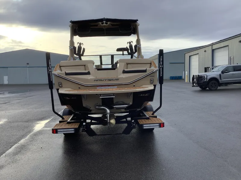 Slide: The Image of 2025 Nautique G23 boat rear view in marina parking lot. - 7