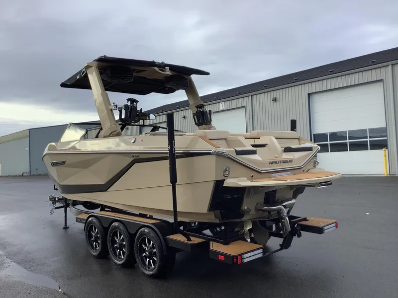 Slide: The Image of 2025 Nautique G23 boat on trailer, parked outside industrial building. - 8