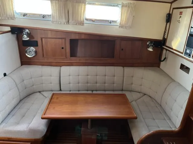 Slide: The Image of Cozy interior of 1999 Grand Banks Eastbay 38 with cushioned seating and wooden table. - 1