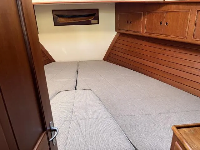 Slide: The Image of Interior cabin of 1999 Grand Banks Eastbay 38 with wooden paneling and bed. - 17