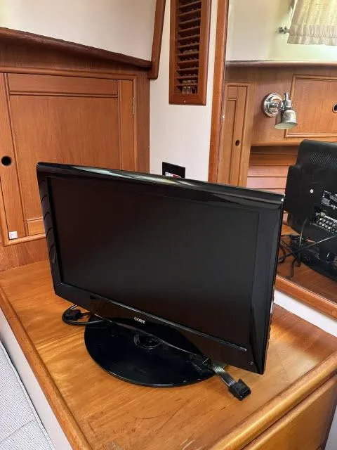 Slide: The Image of Flat-screen TV on wooden cabinet inside 1999 Grand Banks Eastbay 38 yacht. - 24